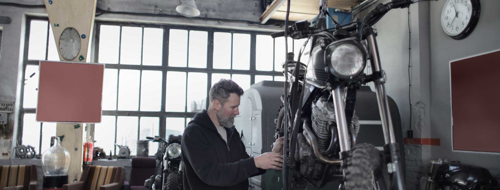 man fixing motorcycle